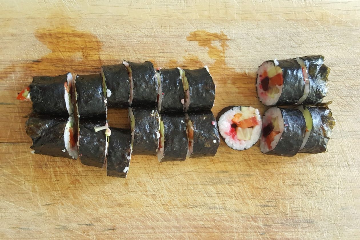 Die in Sushis geschnittenen Sushi-Rollen auf einem Brett.